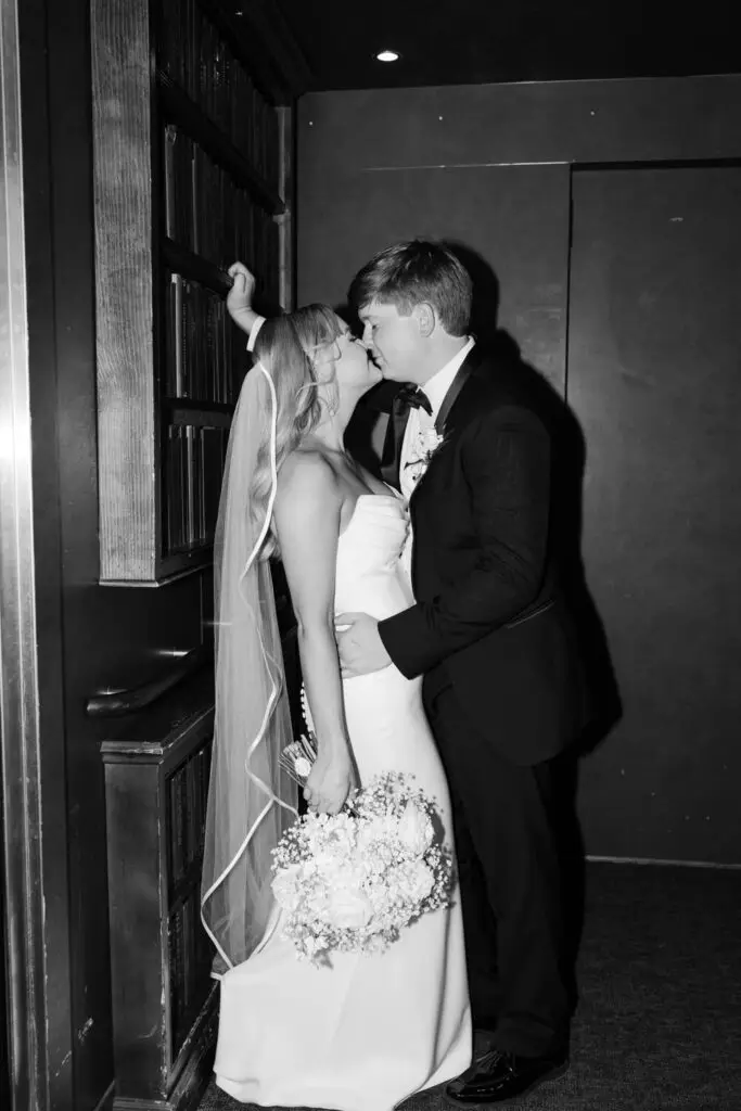 Bride and groom share an intimate kiss in an elevator with bouquet in hand, captured in Mississippi at The Faulkner by Honeysuckle Hollow Wedding Planning