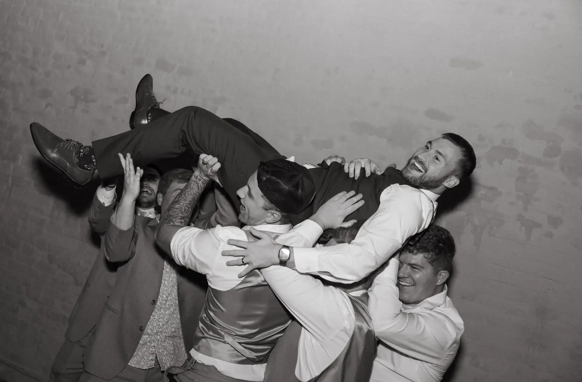 Groomsmen lift the groom in celebration during a lively Mississippi wedding reception.